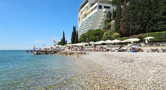 Kieselstrand, Sonnenschirme, Sonnenliegen | © (c) Grandhotel Bernardin